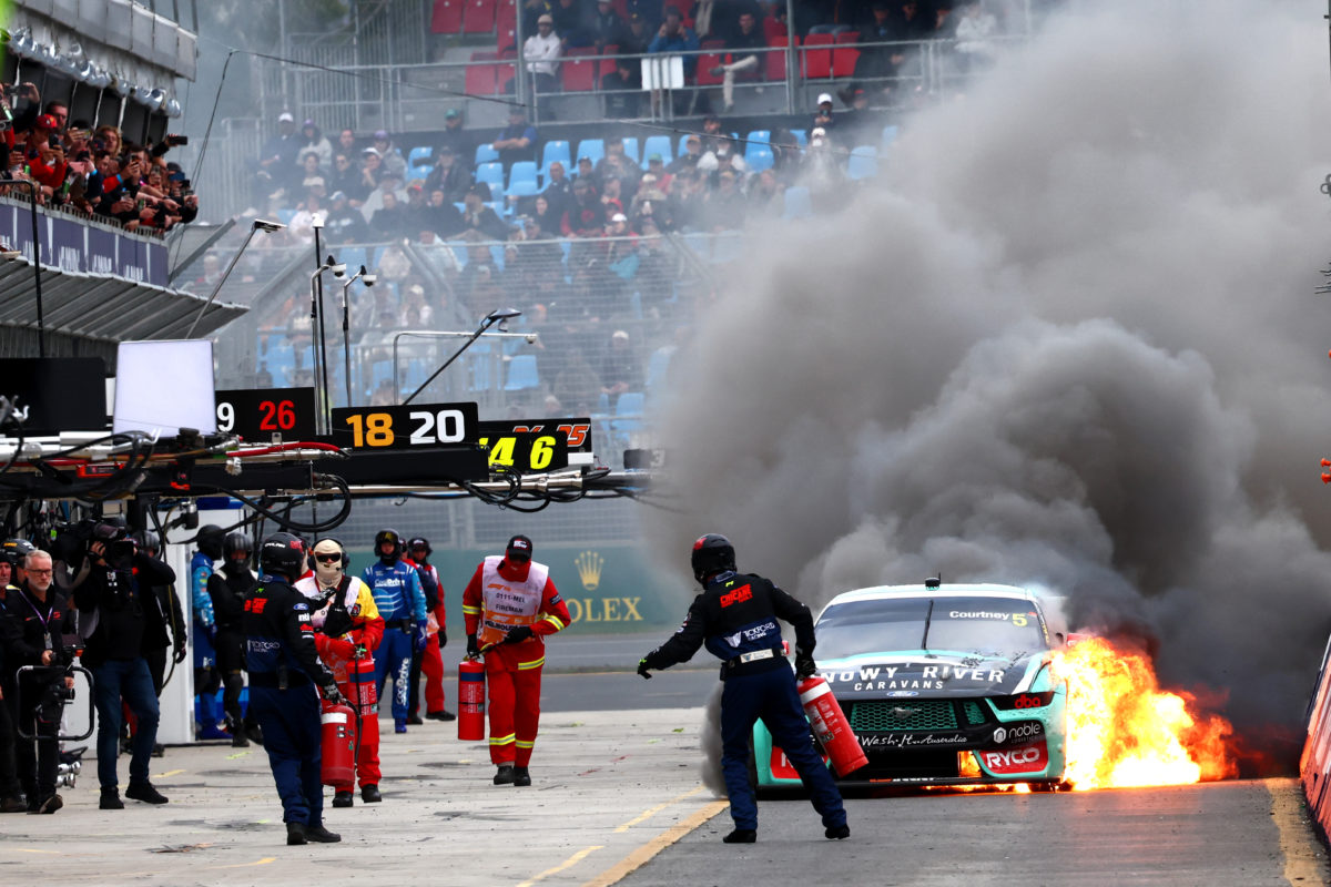 James Courtney's Ford Mustang arrives in the pits on fire at the Formula 1 Australian Grand Prix