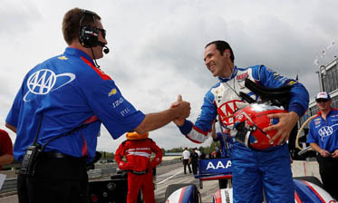 Helio Castroneves, right, celebrates his pole position with his Penske team