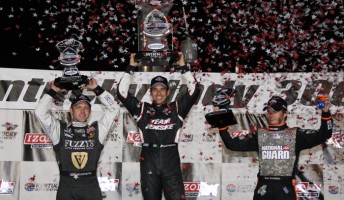 Helio Castroneves celebrates victory in Kentucky alongside the Panther Racing pair of Ed Carpenter (left) and Dan Wheldon