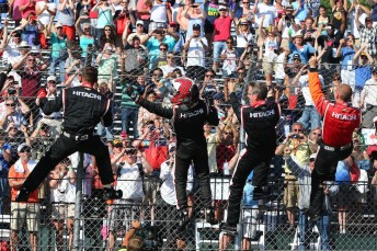 Helio Castroneves does his Spiderman impersonation with Team Penske crew members at Belle Isle