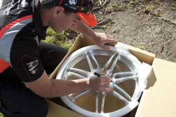 Craig Lowndes signing the wheel that has been won by avid Speedcafe.com reader Jason Mitchell