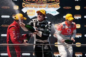 Rick Kelly celebrates his second place on the Island podium with Garth Tander and Jamie Whincup