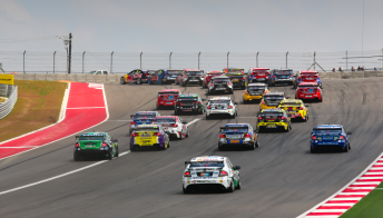 The V8 Supercars field heads through Turn 1 at the COTA