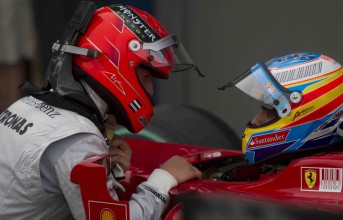 Seven-time world champion Michael Schumacher speaks with two-time world champ Fernando Alonso