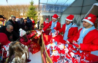 Jules Bianchi assists Fernando Alonso and Felipe Massa give presents at a Christmas party in Maranello