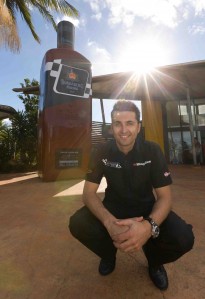 Fabian Coulthard stands in front of a very large bottle of Bundy Racing rum