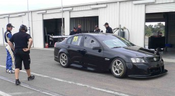 Nathan Pretty stands to the left of the Kelly Racing Commodore VE