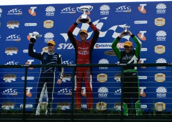 Garth Tander stands on top of the Sydney Telstra 500 podium as the first-ever V8 race winner at the circuit. Mark Winterbottom (left) and Jason Bright (right) joined him
