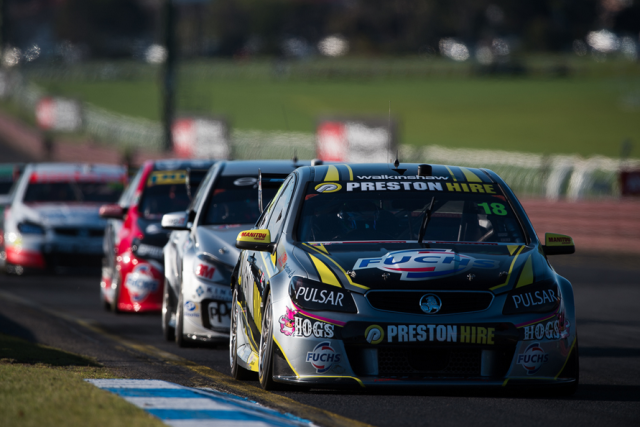 The Team 18 Holden leading a train of cars at Sandown