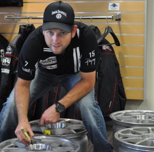 Todd Kelly signs the first batch of wheels that are being sold to make way for V8 Supercar