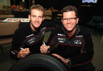 Will Davison and Garth Tander with a special signed Dunlop tyre that will be auctioned this Saturday at Queensland Raceway