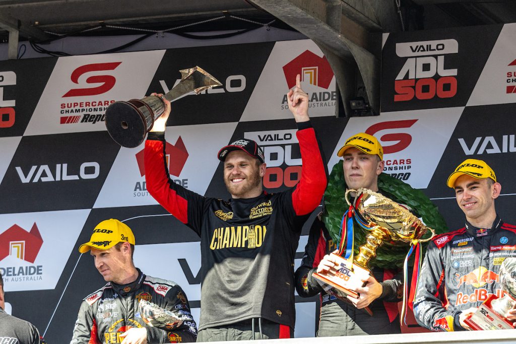26-year-old, newly crowned Supercars champion Brodie Kostecki shares the podium with Race 28 winner Matt Payne (centre-right), runner-up and fellow 21-year-old Broc Feeney (right), and 38-year-old podium finisher David Reynolds (left). Image: InSdye Media