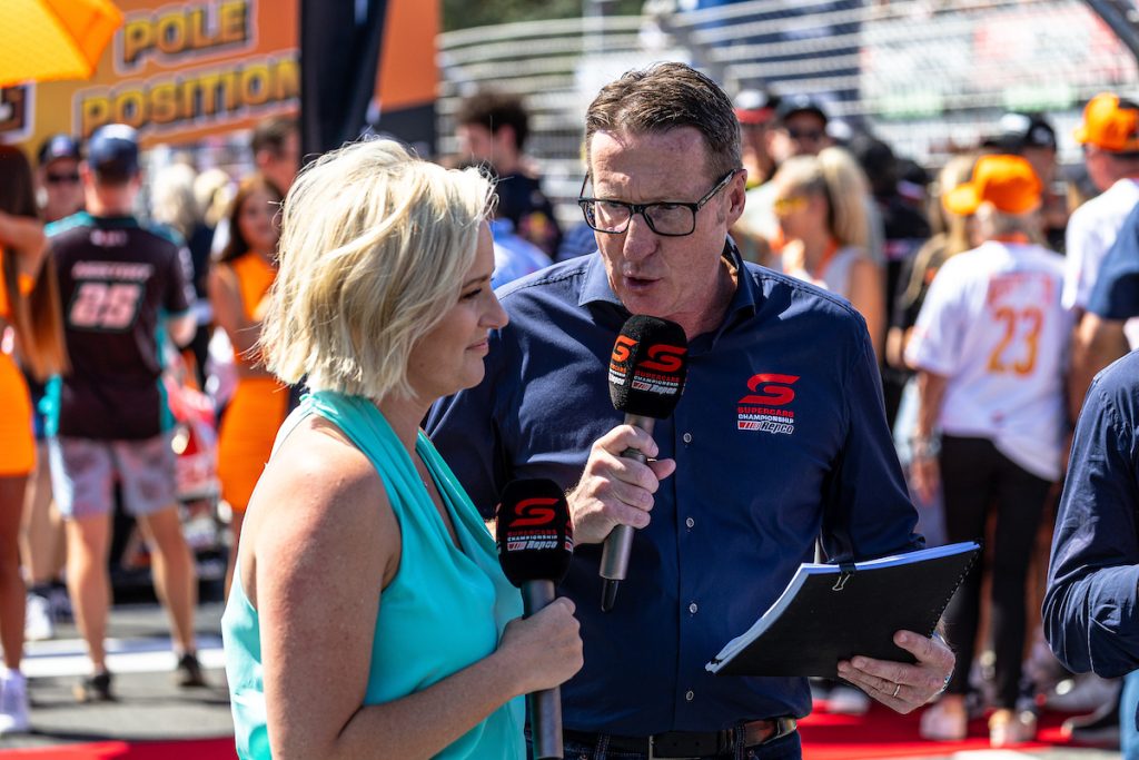 Fox Sports host Jessica Yates and commentator Mark Skaife stand on the grid at the 2023 Gold Coast 500